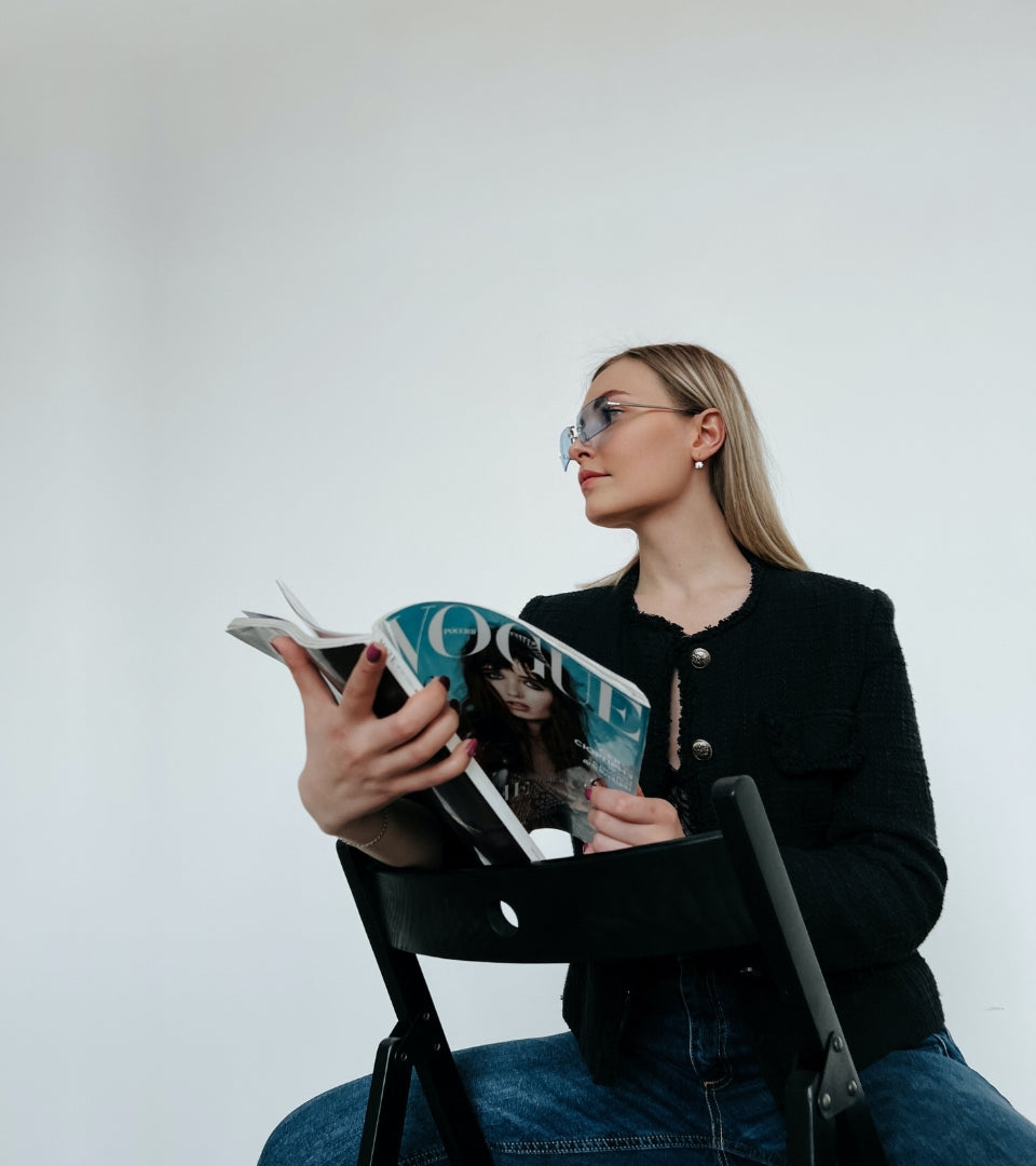 Cette image représente une femme lisant l'un de nos journaux sur la mode.
