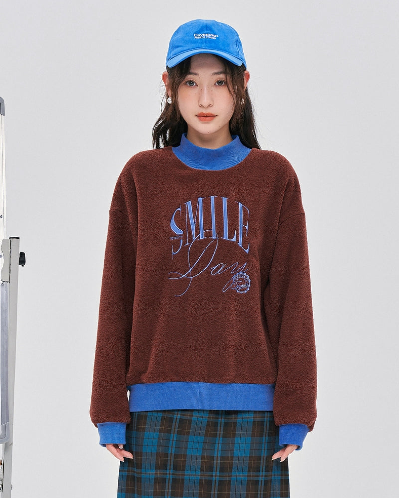 Pull en matière Pilou Pilou de couleur rouge marron et bleu